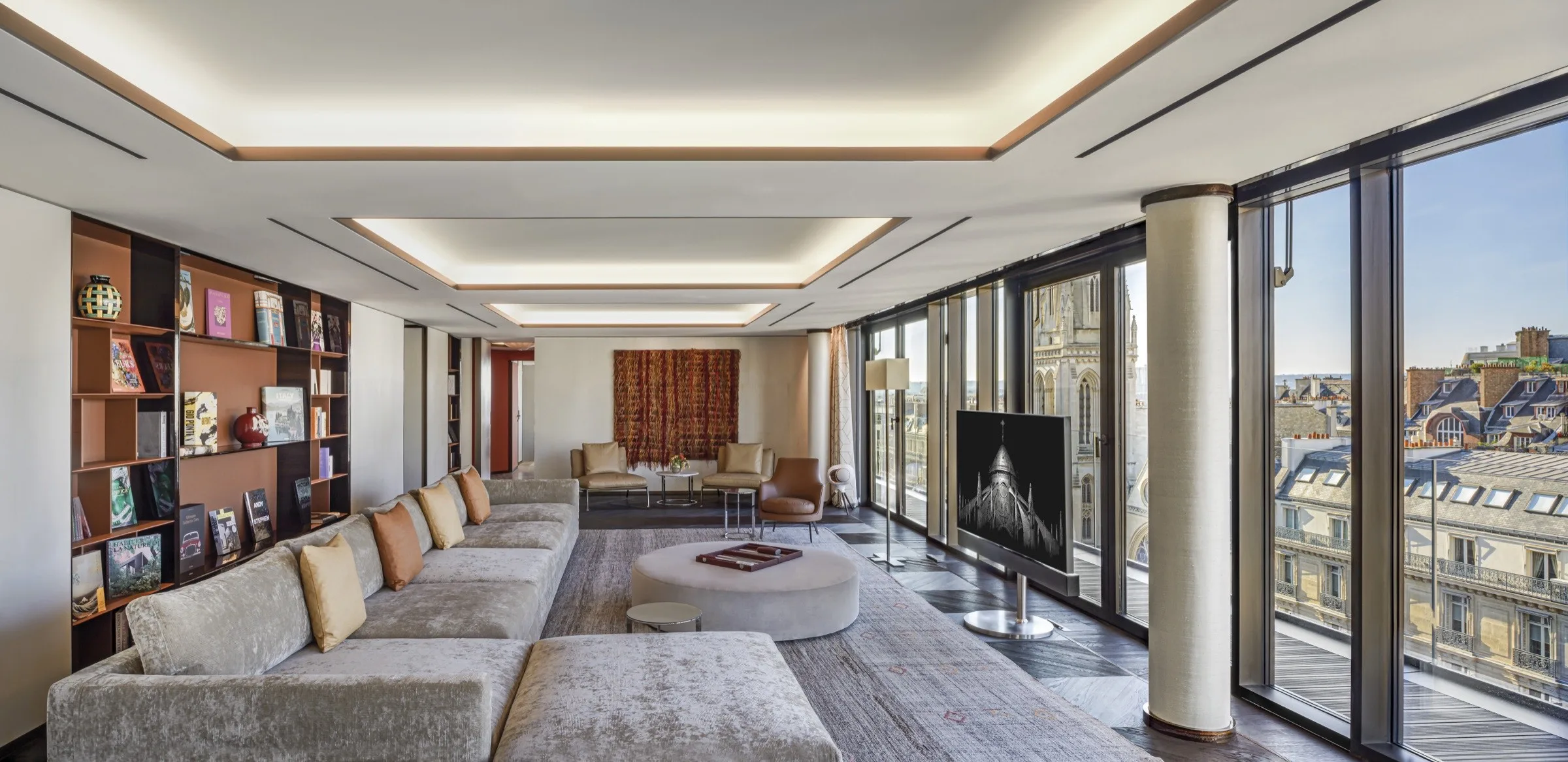 Le salon-bibliothèque de la Bvlgari Penthouse, au Bvlgari Hotel Paris, avec vue sur les toits de Paris.