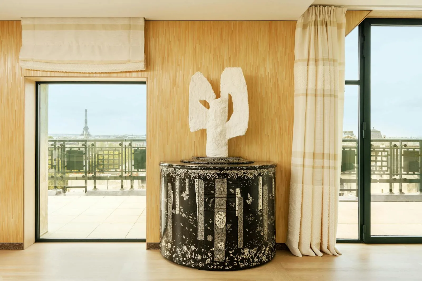 A corner of The Apartment at Cheval Blanc Paris, with a contemporary art piece and the Eiffel Tower in view.