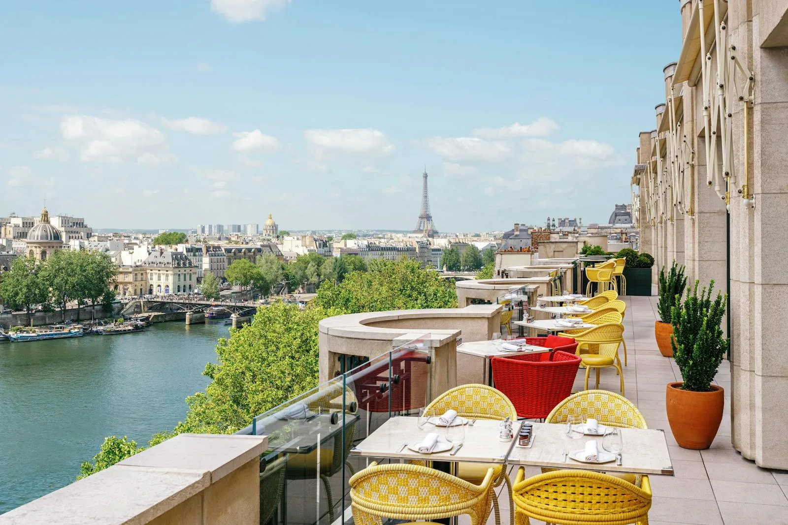 The terrace of Le Tout-Paris, the Michelin-starred brasserie on the 7th floor of Cheval Blanc Paris, overlooking the Seine and the Eiffel Tower.