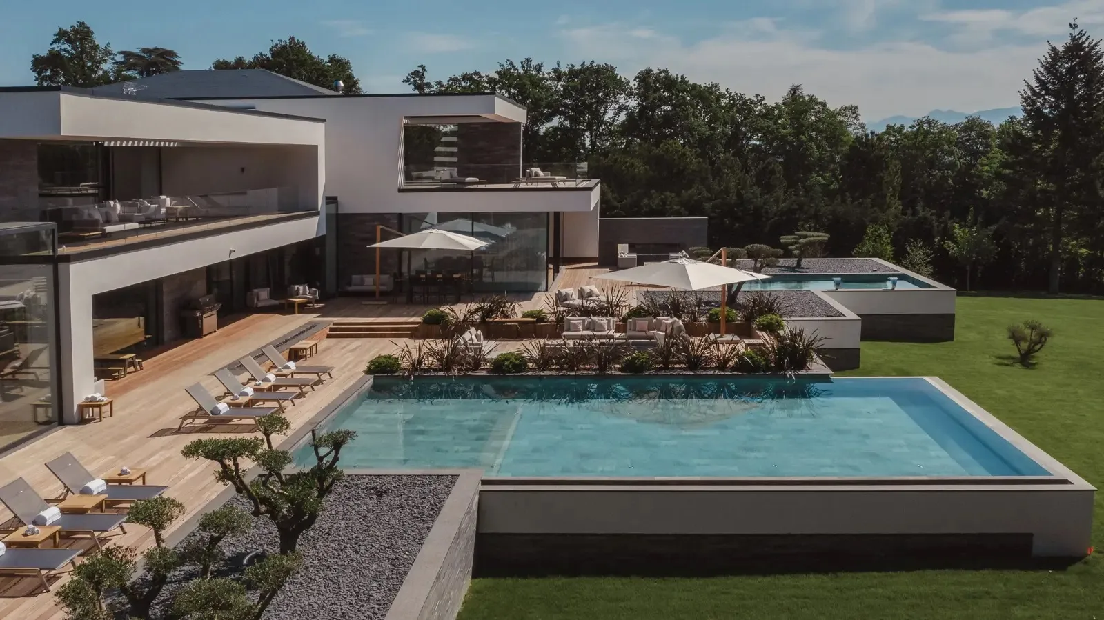 La terrasse, la piscine et le jardin paysager de la villa, vus d’en haut.