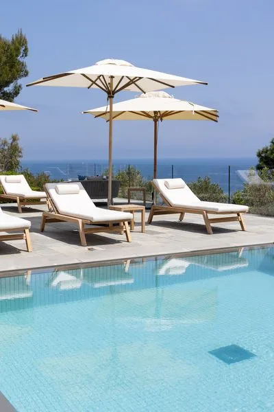 Des chaises longues au bord de la piscine, face à la Méditerranée.