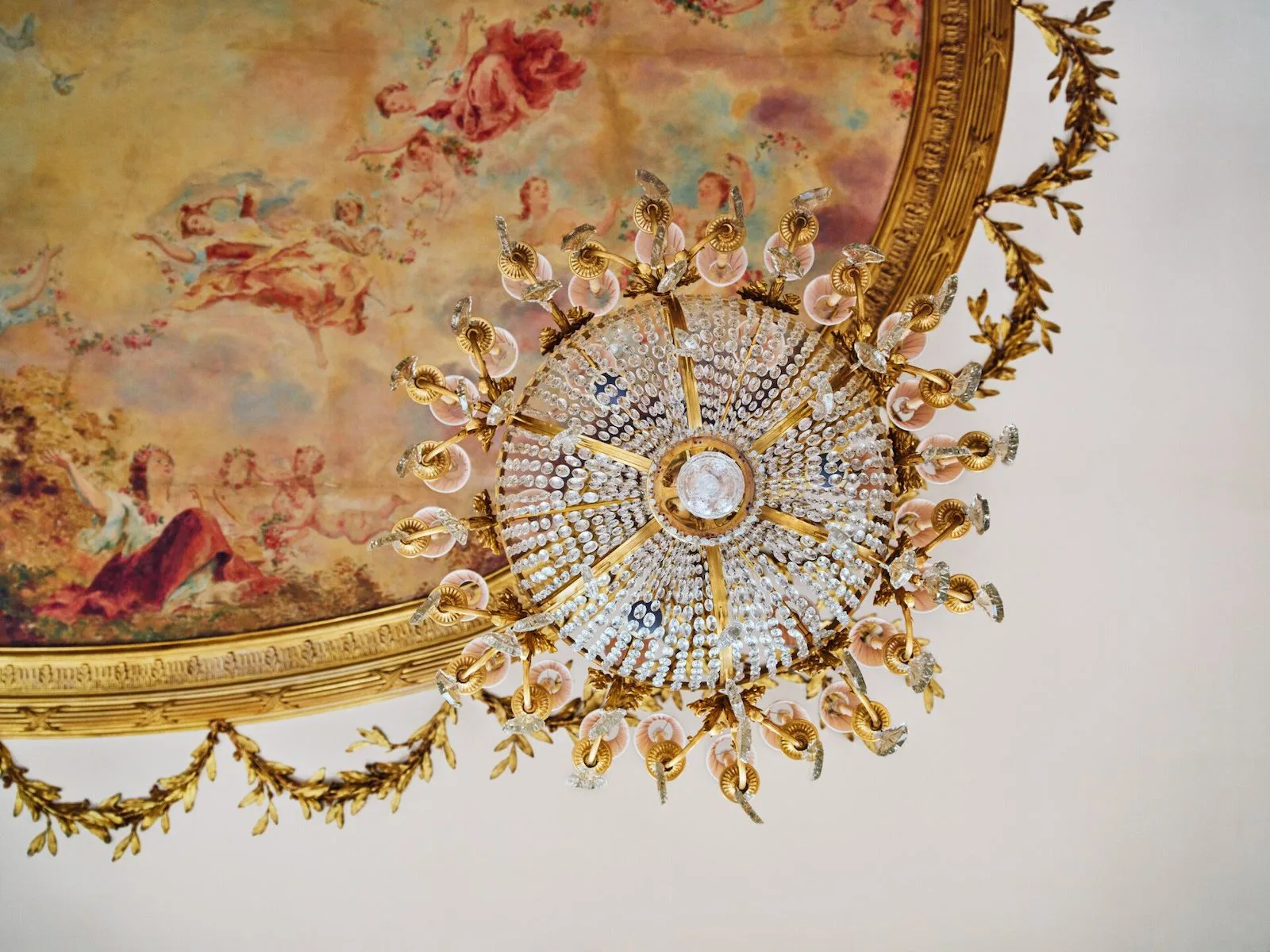 The painted ceiling and crystal chandelier of Restaurant le Meurice Alain Ducasse, inspired by Versailles.