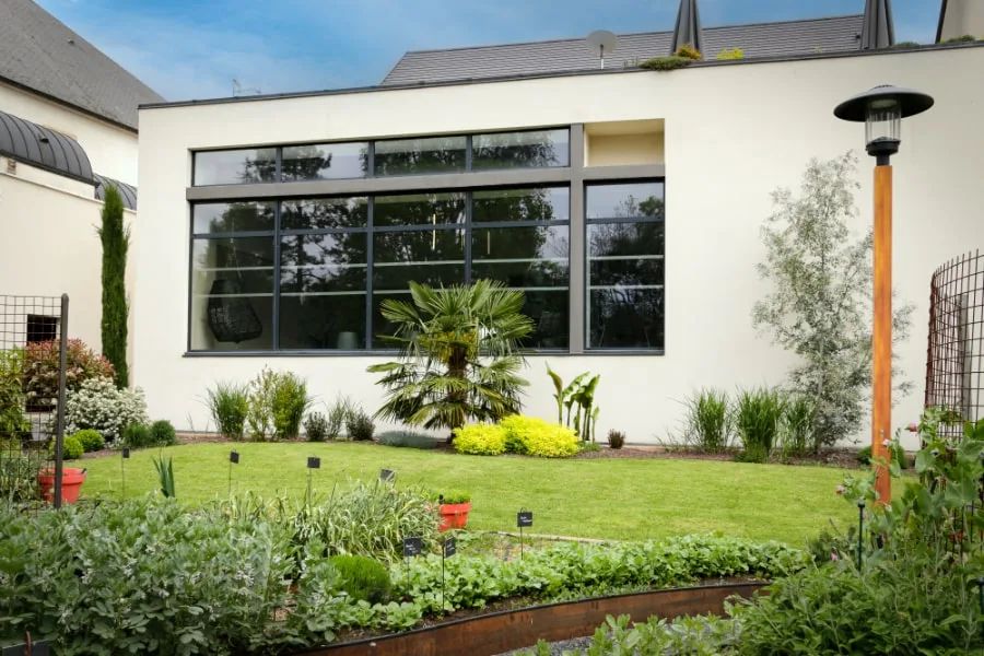 L'aile contemporaine de l'hôtel sur le jardin, avec les toits du village de Vosne-Romanée en arrière-plan.