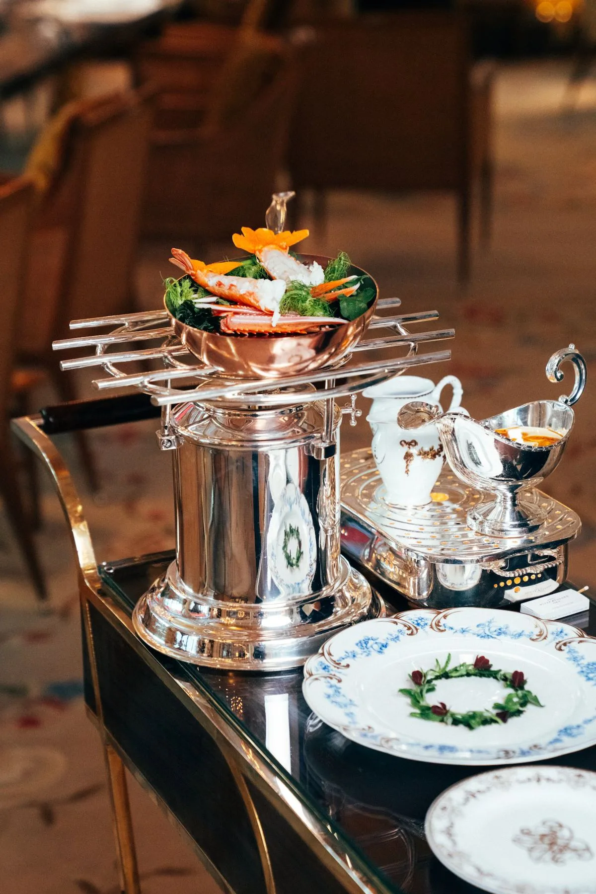 A tableside seafood preparation on a silver trolley at La Grande Table du Plaza Athénée.