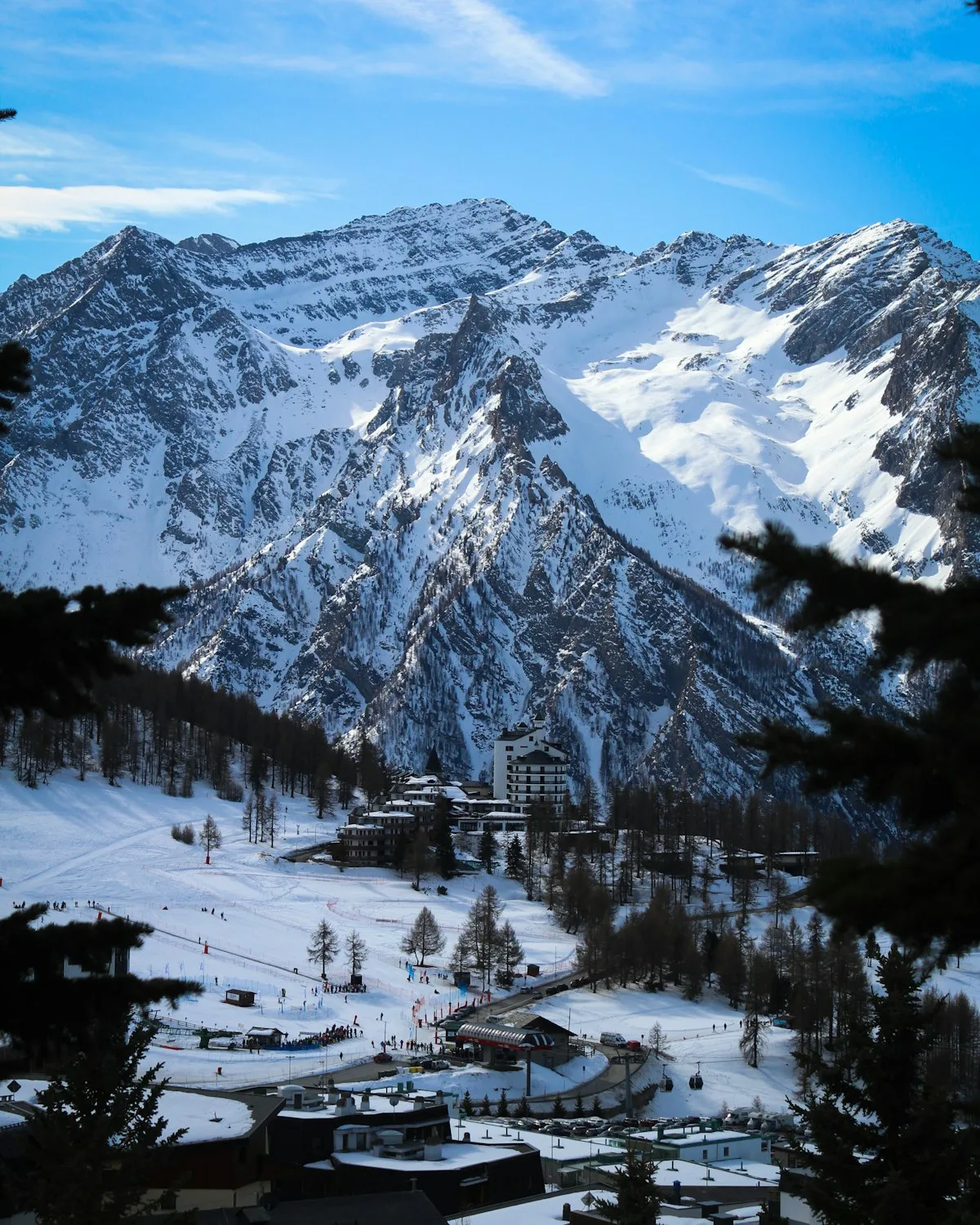 Une montagne enneigée avec un chalet de ski au premier plan, dans les Alpes françaises.