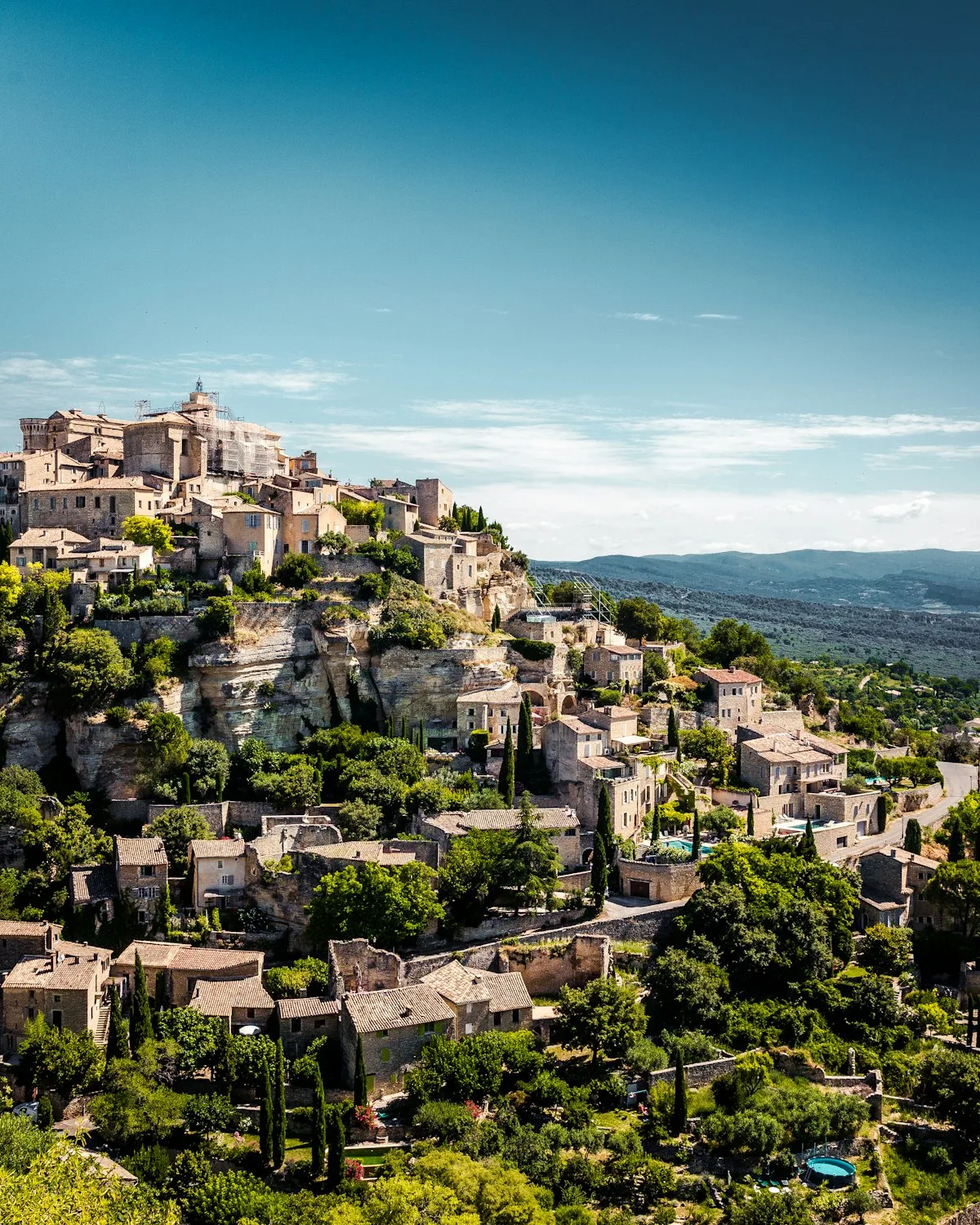 Un village perché en Provence, entouré d'arbres.