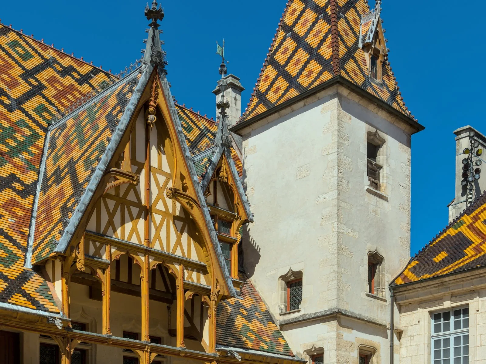 The glazed polychrome tiled roofs and tower of the Hôtel-Dieu in Beaune.