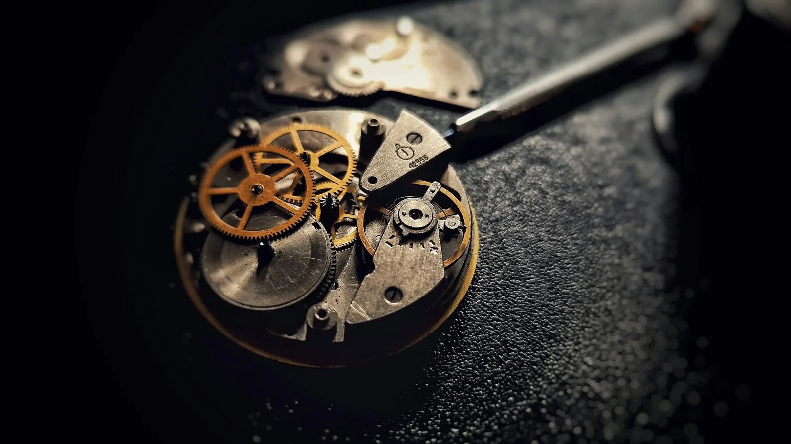 Gros plan sur un mouvement de montre mécanique en cours d'ajustement par un horloger.
