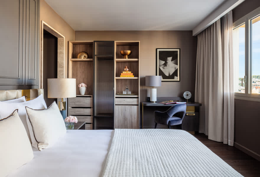 Deluxe Room客房，现代风格，配有办公桌与装饰画框。