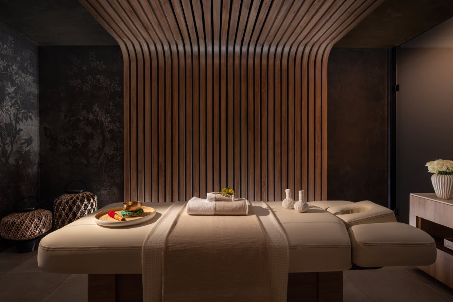 Anantara Spa理疗室，雕刻木质吊顶覆于理疗床上方。