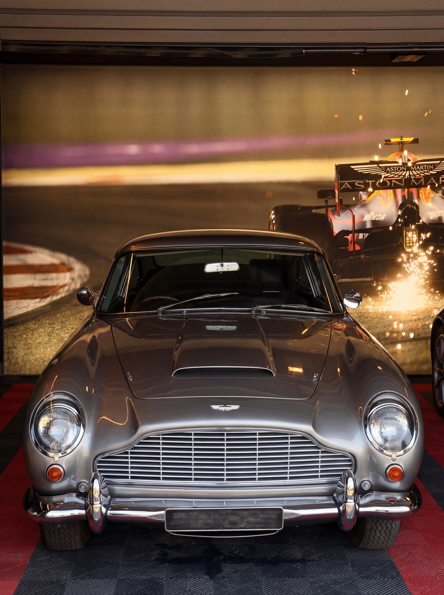La galerie privée de voitures de collection du château, avec une Aston Martin vintage parmi les pièces exposées.