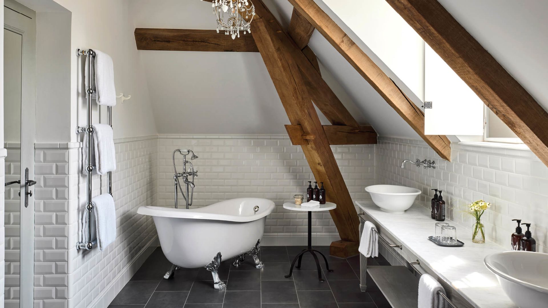 The Montrachet Suite's ensuite bathroom, a clawfoot tub set beneath exposed oak rafters.