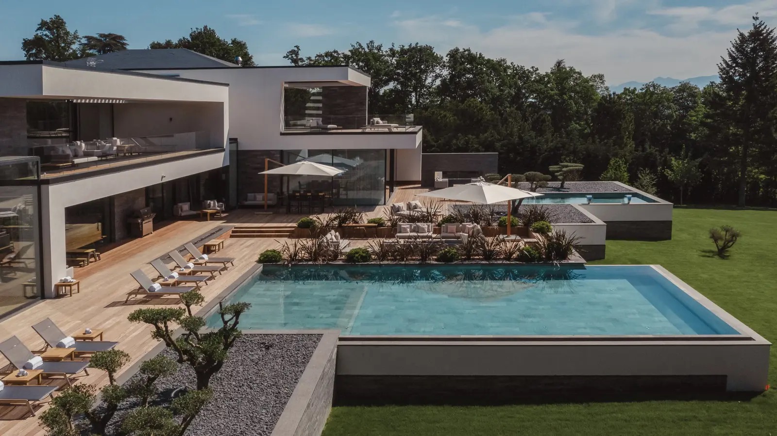La terrasse, la piscine et le jardin paysager de la villa, vus d’en haut.