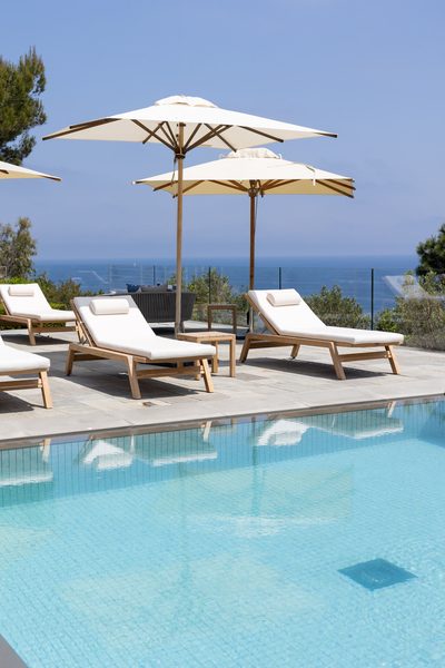 Sun loungers beside the pool, facing the open Mediterranean.
