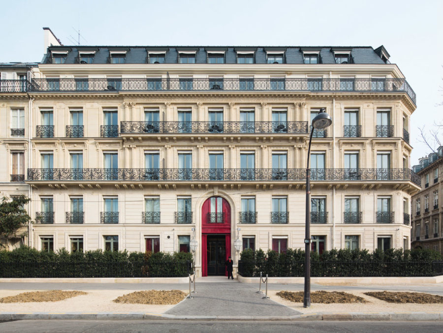 Фасад отеля-особняка La Réserve Paris с фирменной красной дверью.