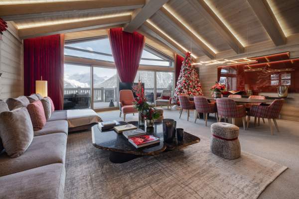 The living and dining area of Suite-Chalet K8 at Le K2 Palace, with mountain views through floor-to-ceiling windows.