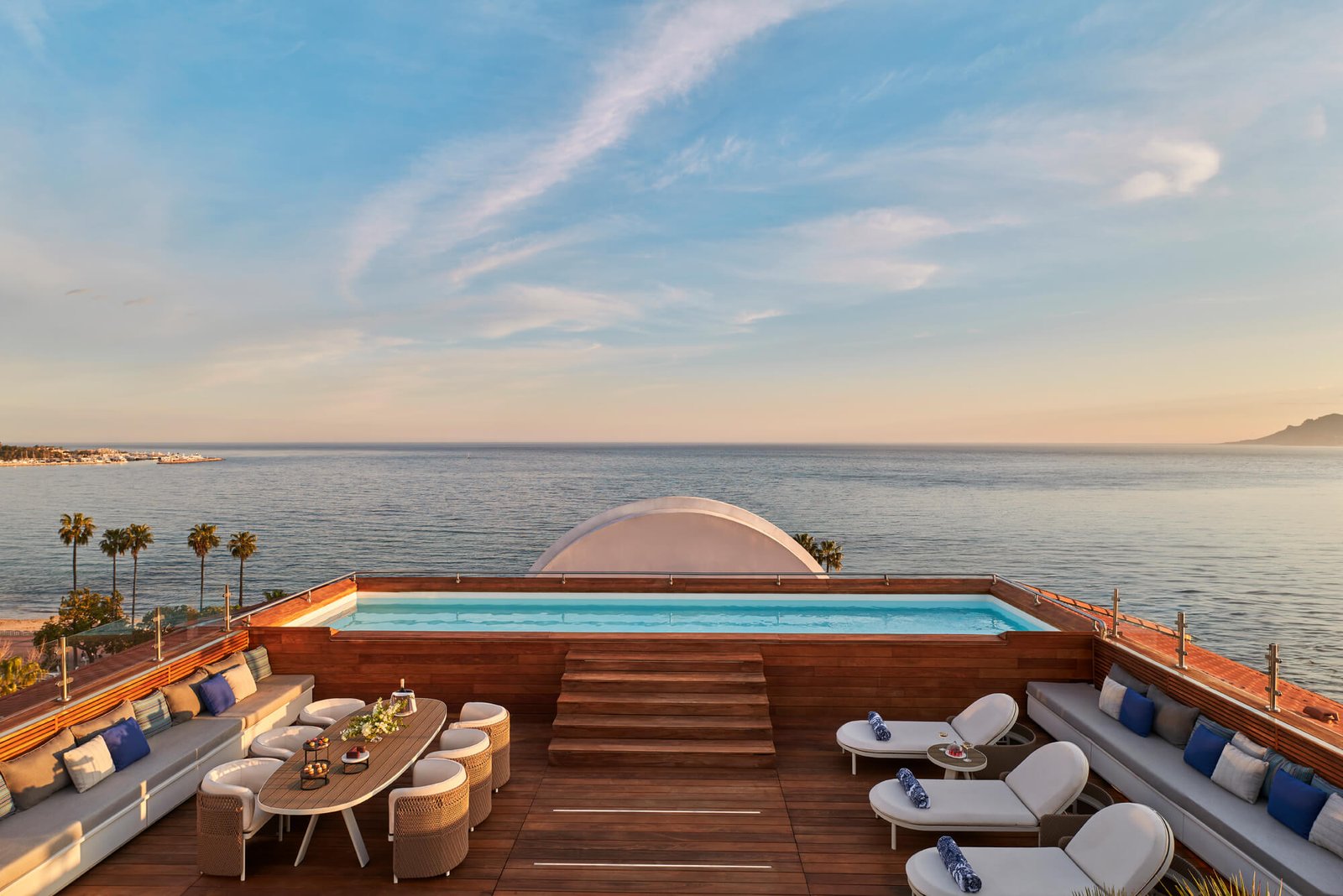 La terrasse privée en toiture de la Suite Majestic et sa piscine à débordement chauffée, au crépuscule.