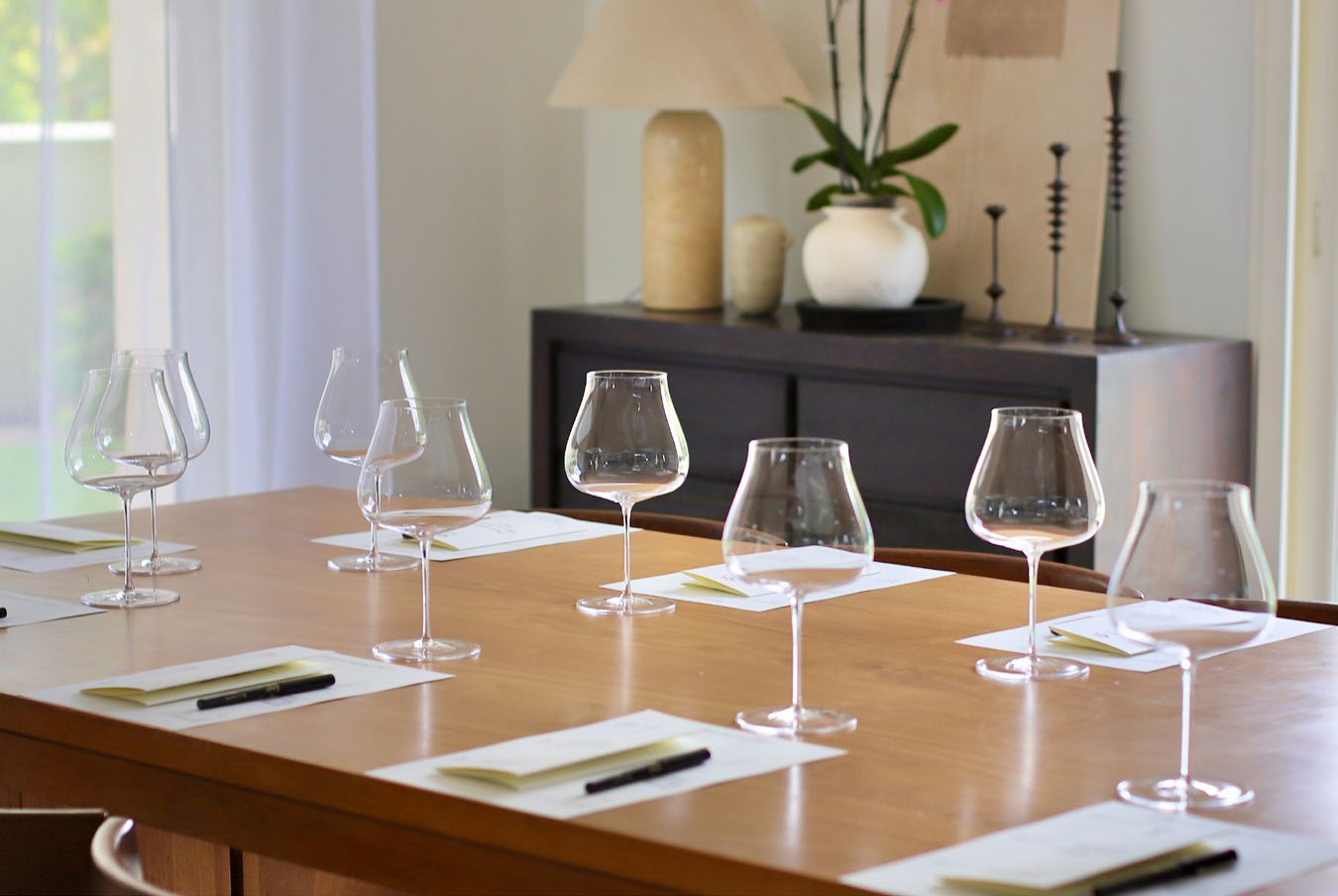 Wine glasses and tasting notes set out along a wooden table at Maison Kairui.