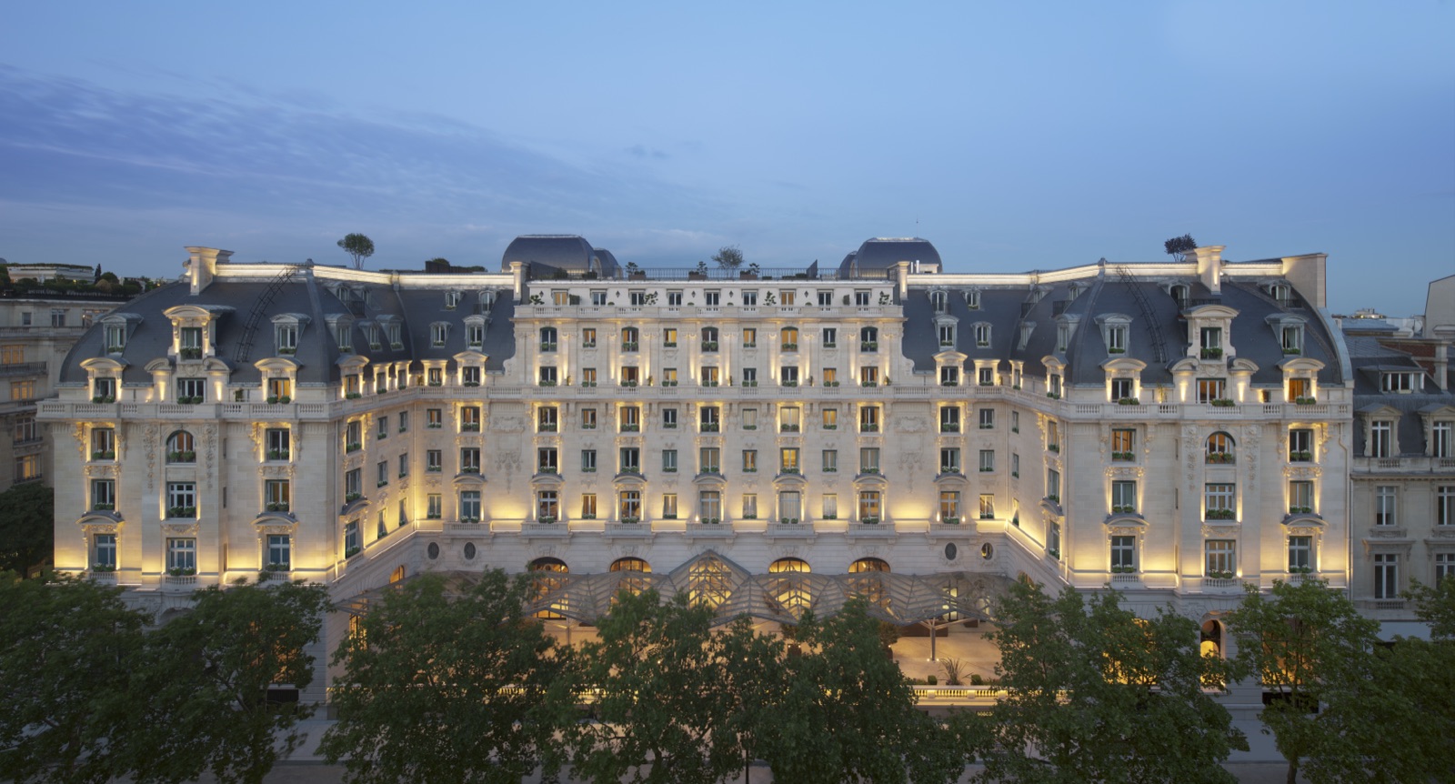 Отель The Peninsula Paris, отреставрированное здание 1908 года в стиле Belle Époque, в сумерках.