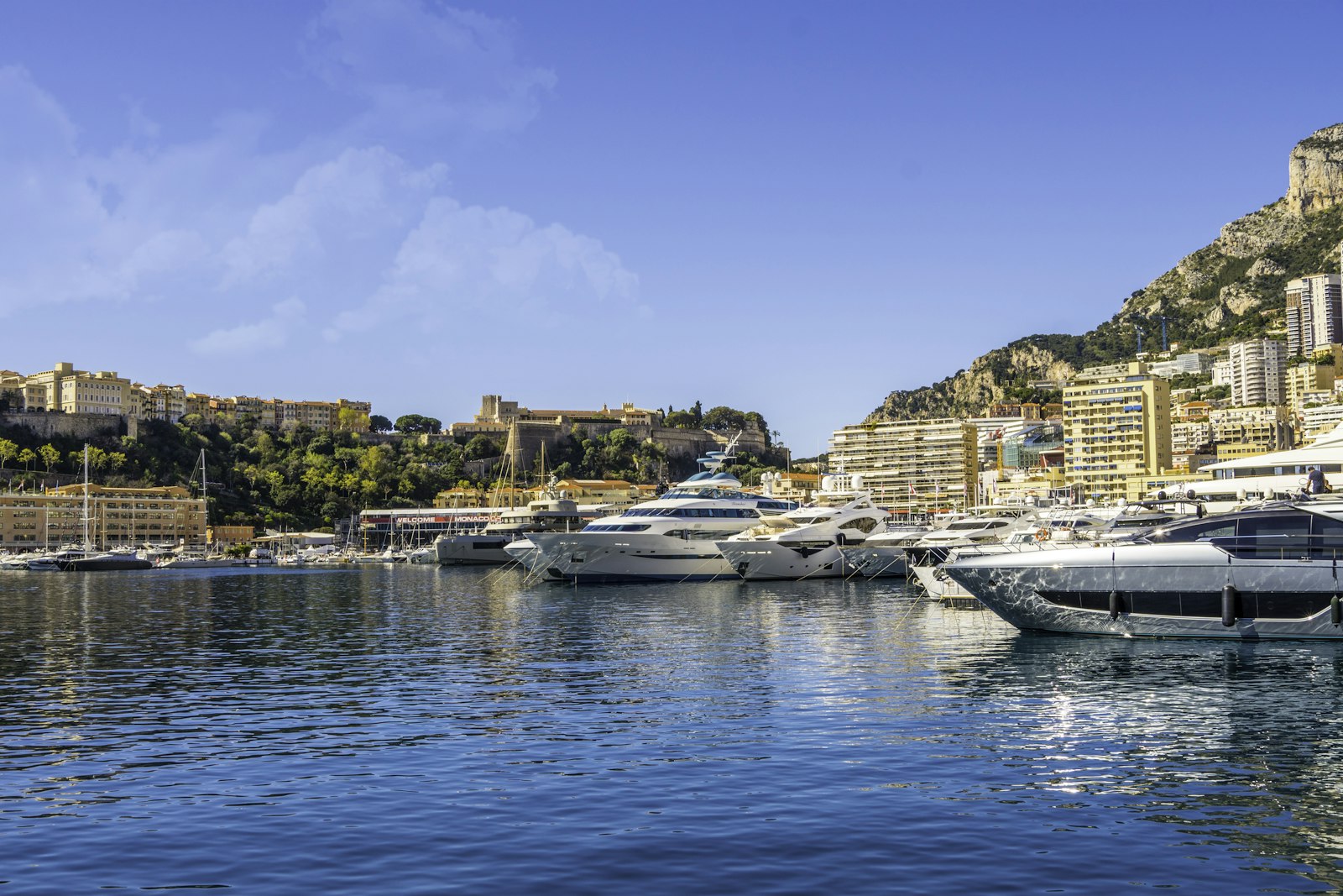 Yachts de luxe amarrés dans un port méditerranéen ensoleillé.