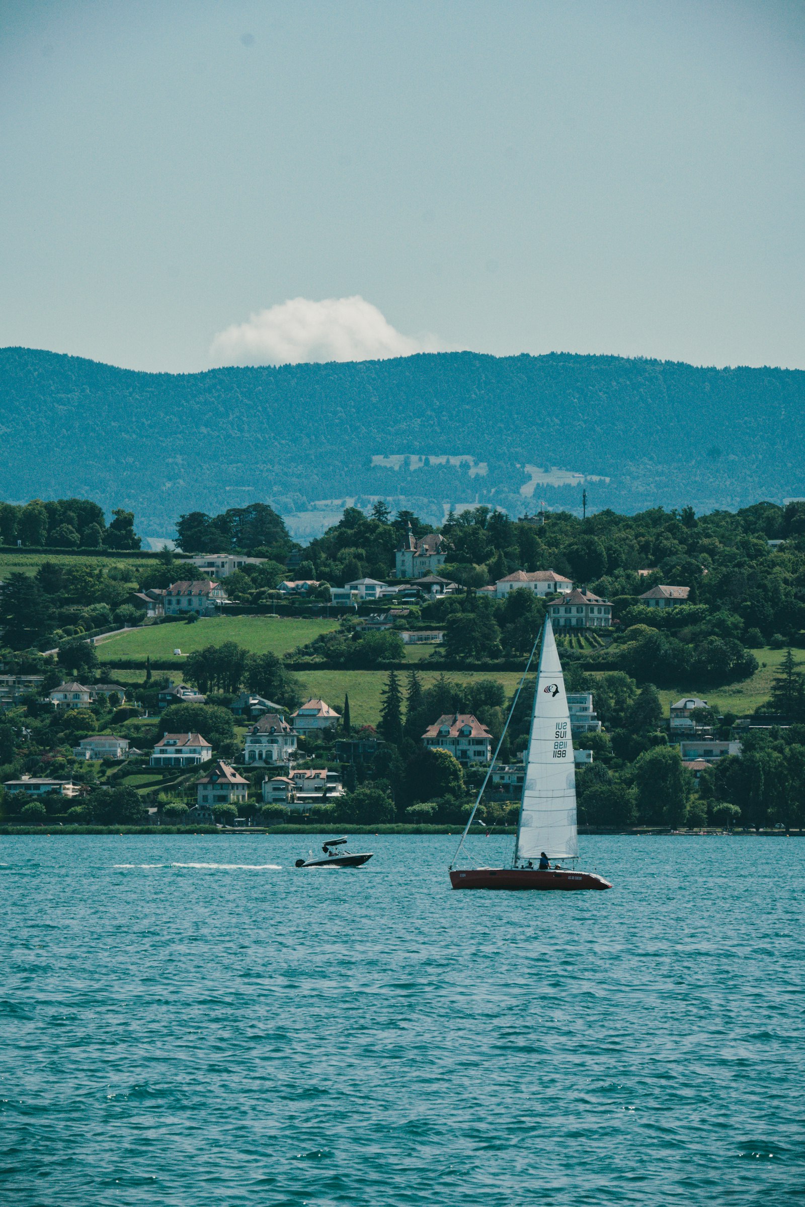 A sailboat on Lake Geneva with the town in the background.