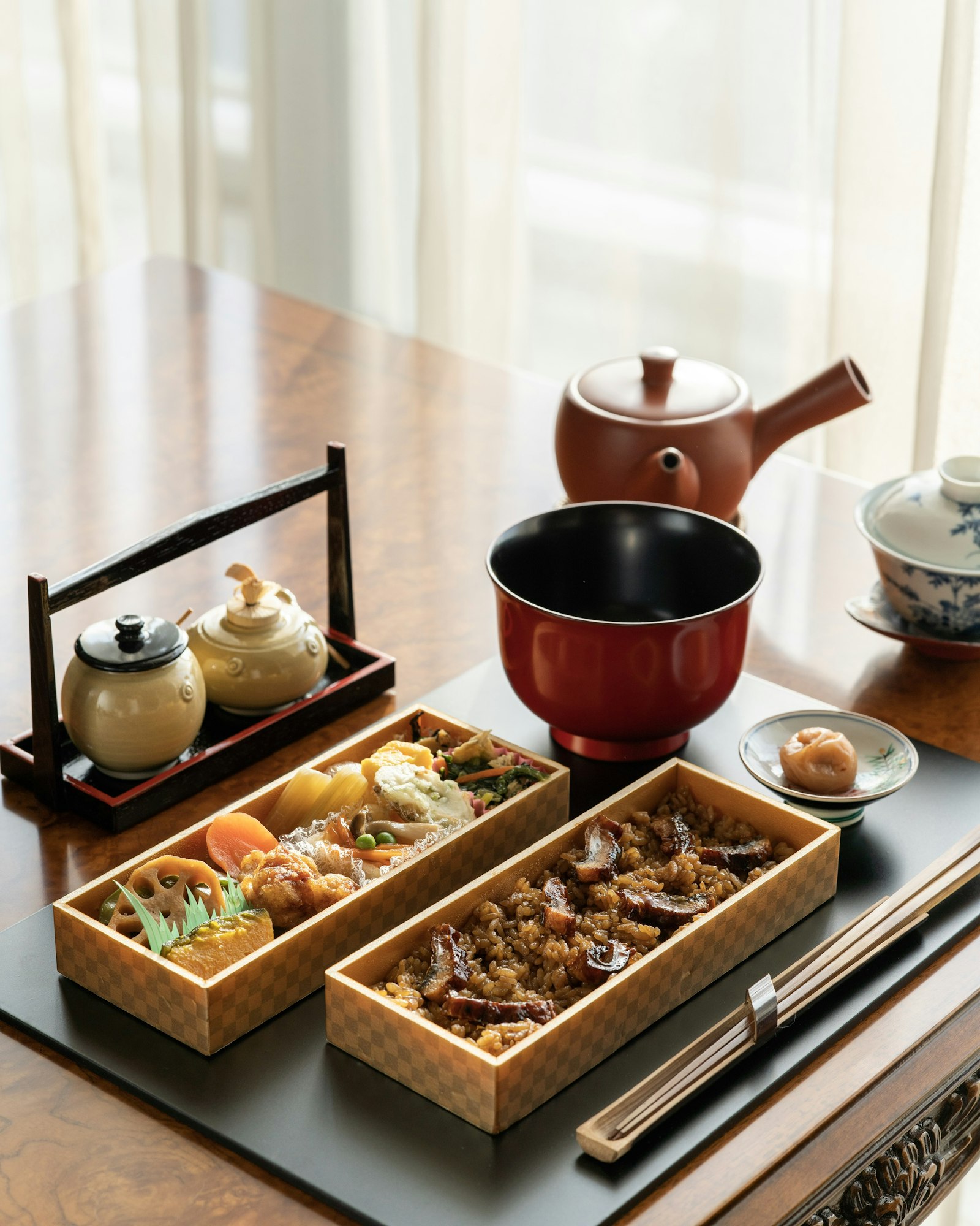 Un repas japonais de style kaiseki, à plusieurs services, servi sur des plateaux.