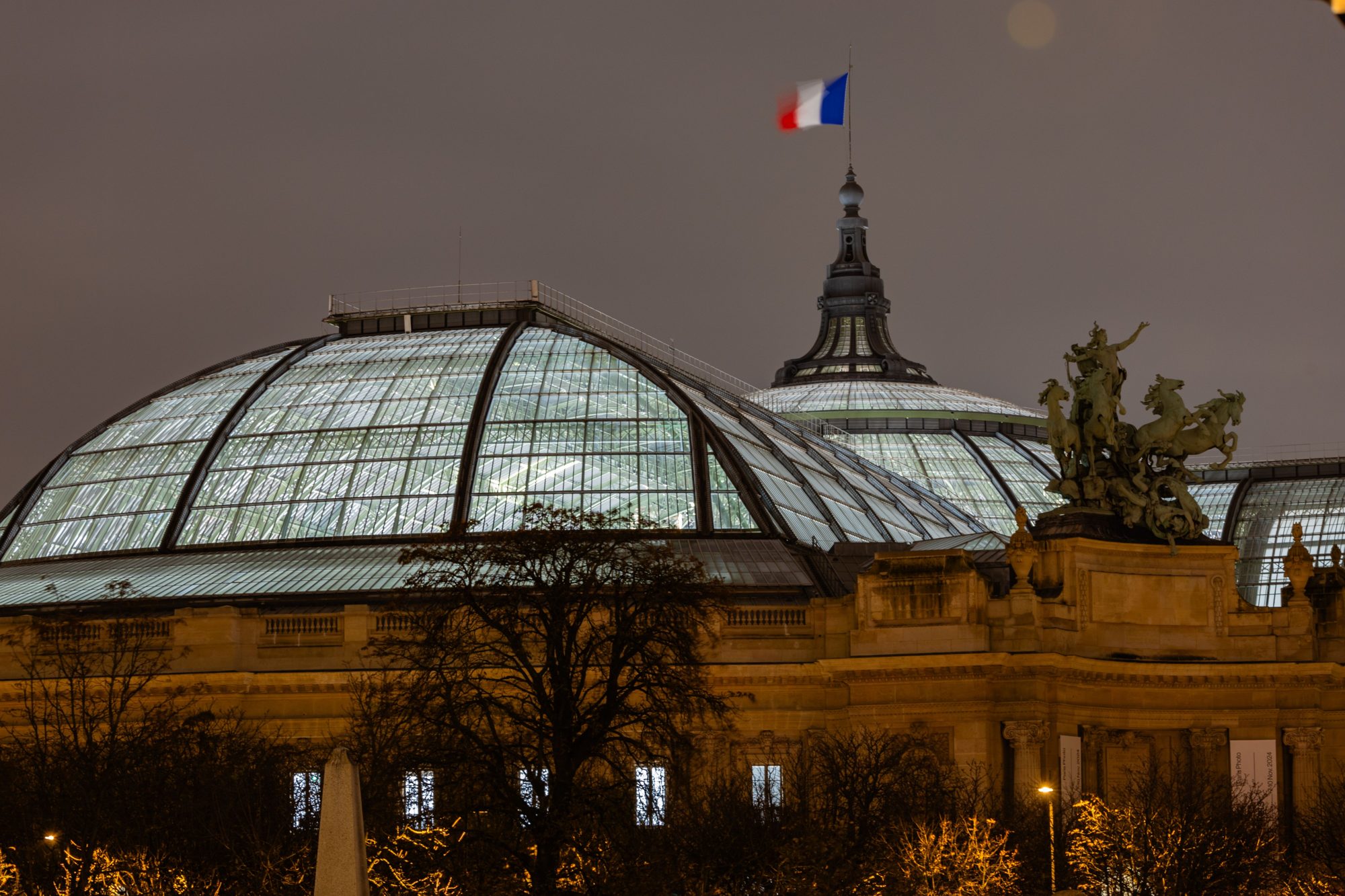 夜晚的 Grand Palais 玻璃穹顶,屋顶上方有一面法国国旗