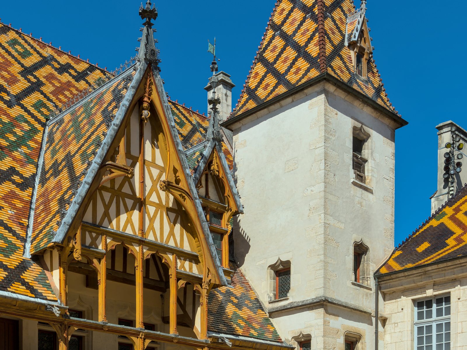 The glazed polychrome tiled roofs and tower of the Hôtel-Dieu in Beaune.