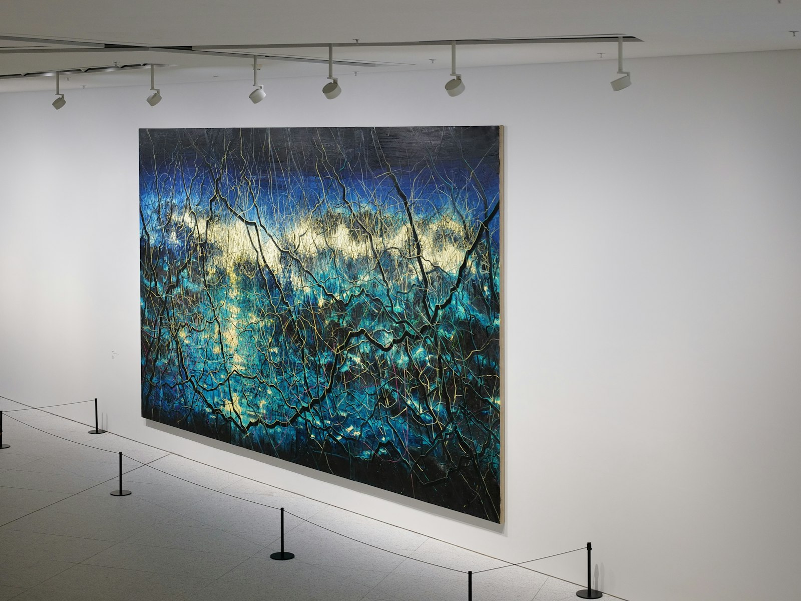 Une grande toile exposée dans une galerie de musée d'art.