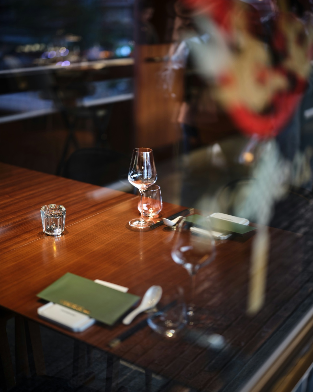 An elegant restaurant table set with wine glasses and menus, no diners visible.