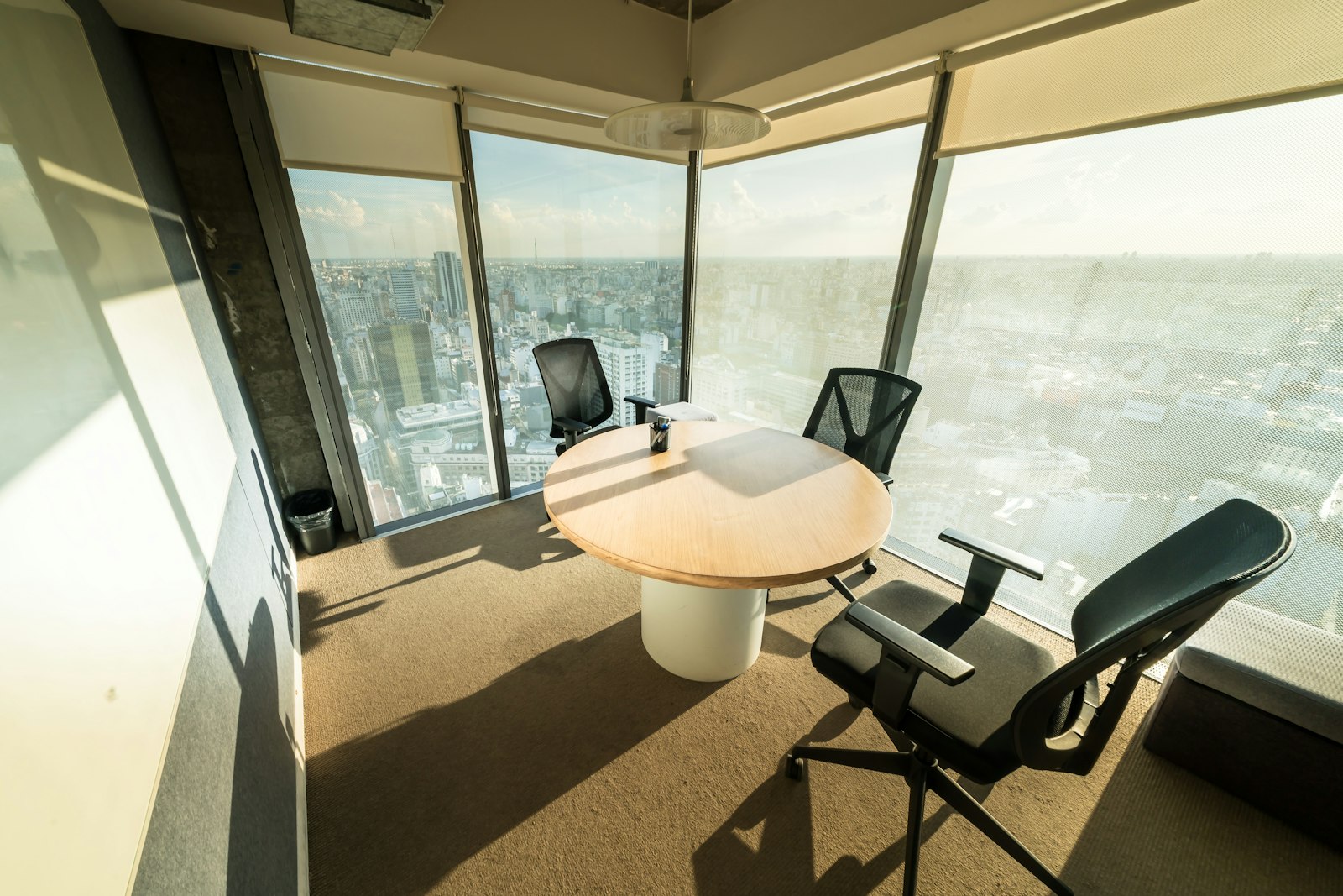 A modern meeting room with a panoramic city skyline view.