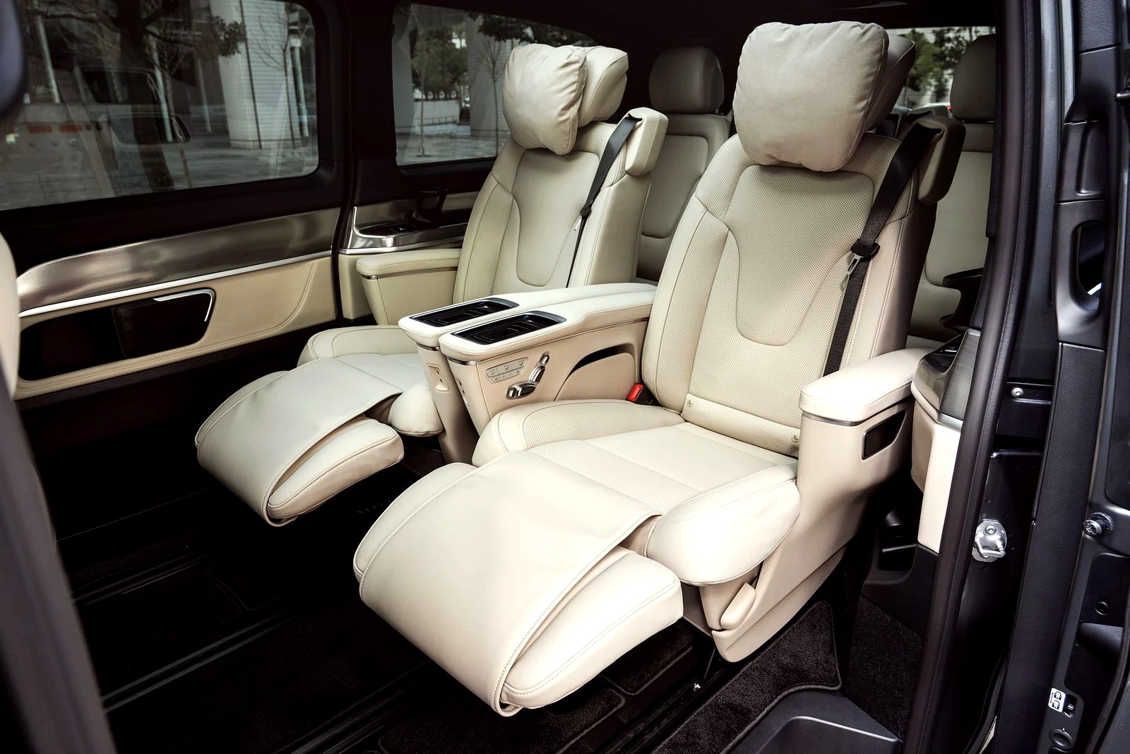 Individual reclining leather captain’s chairs with extending footrests, in a wide-body luxury van.
