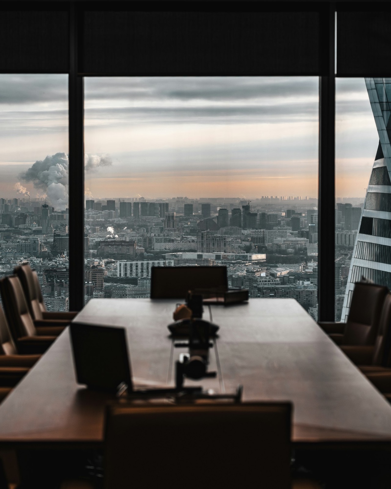 Une salle de conseil vide avec une vue panoramique sur la ville au crépuscule.