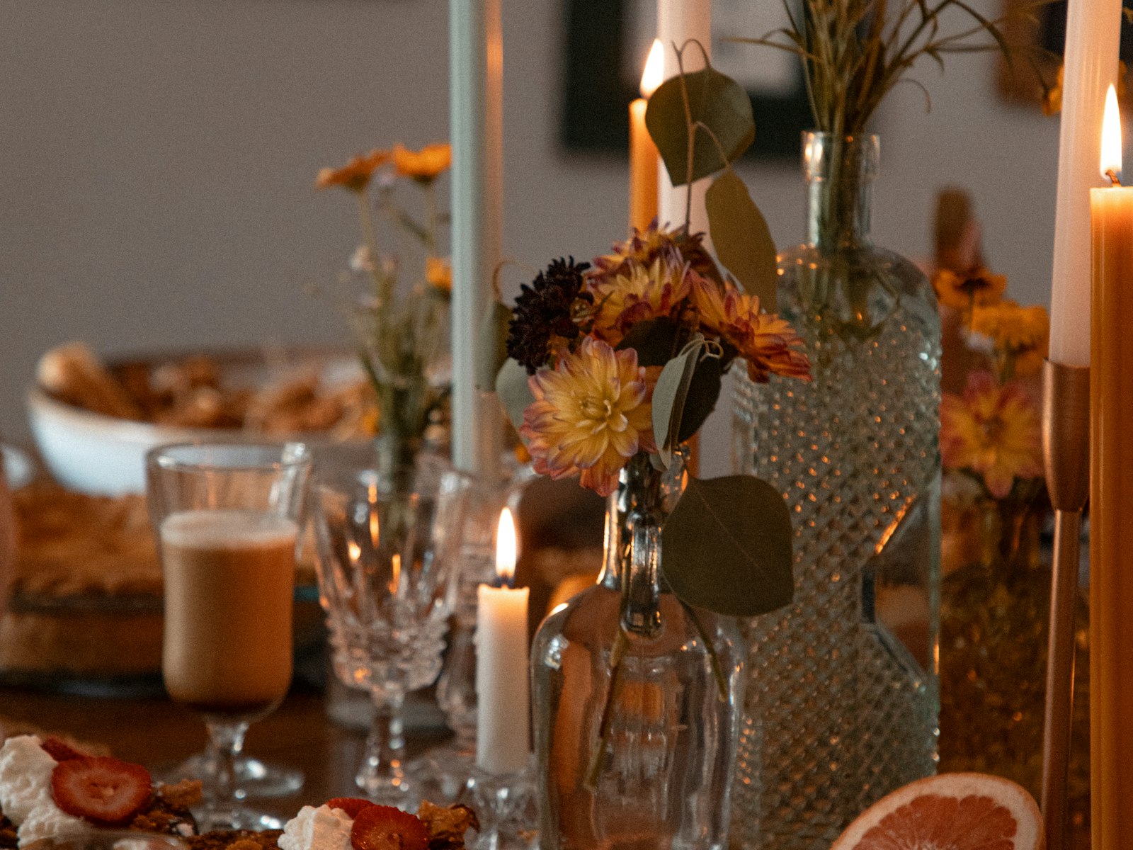 A candlelit dinner table set with plates of food.